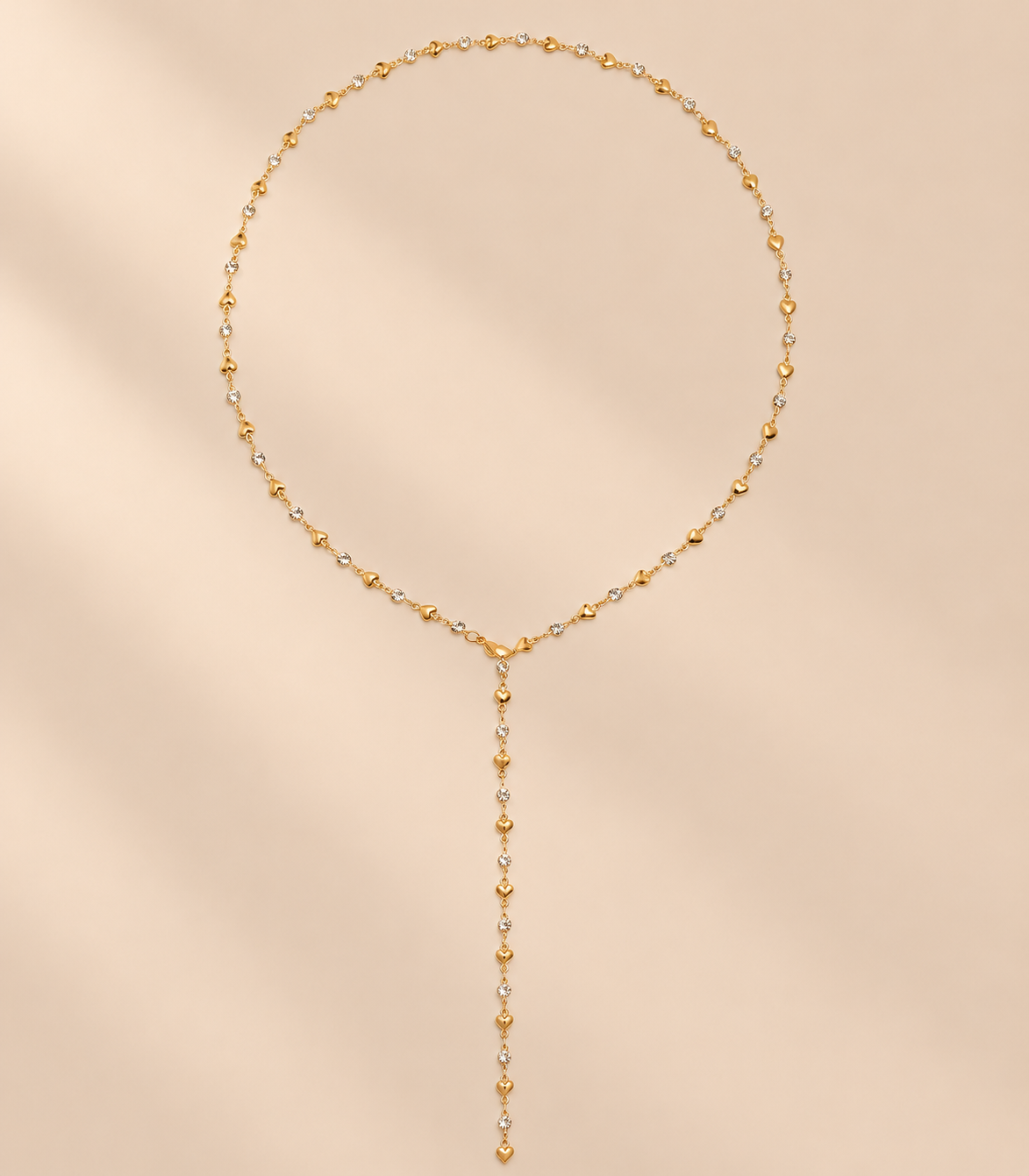 Amorielle Rhinestone Heart Necklace — warm beige studio background