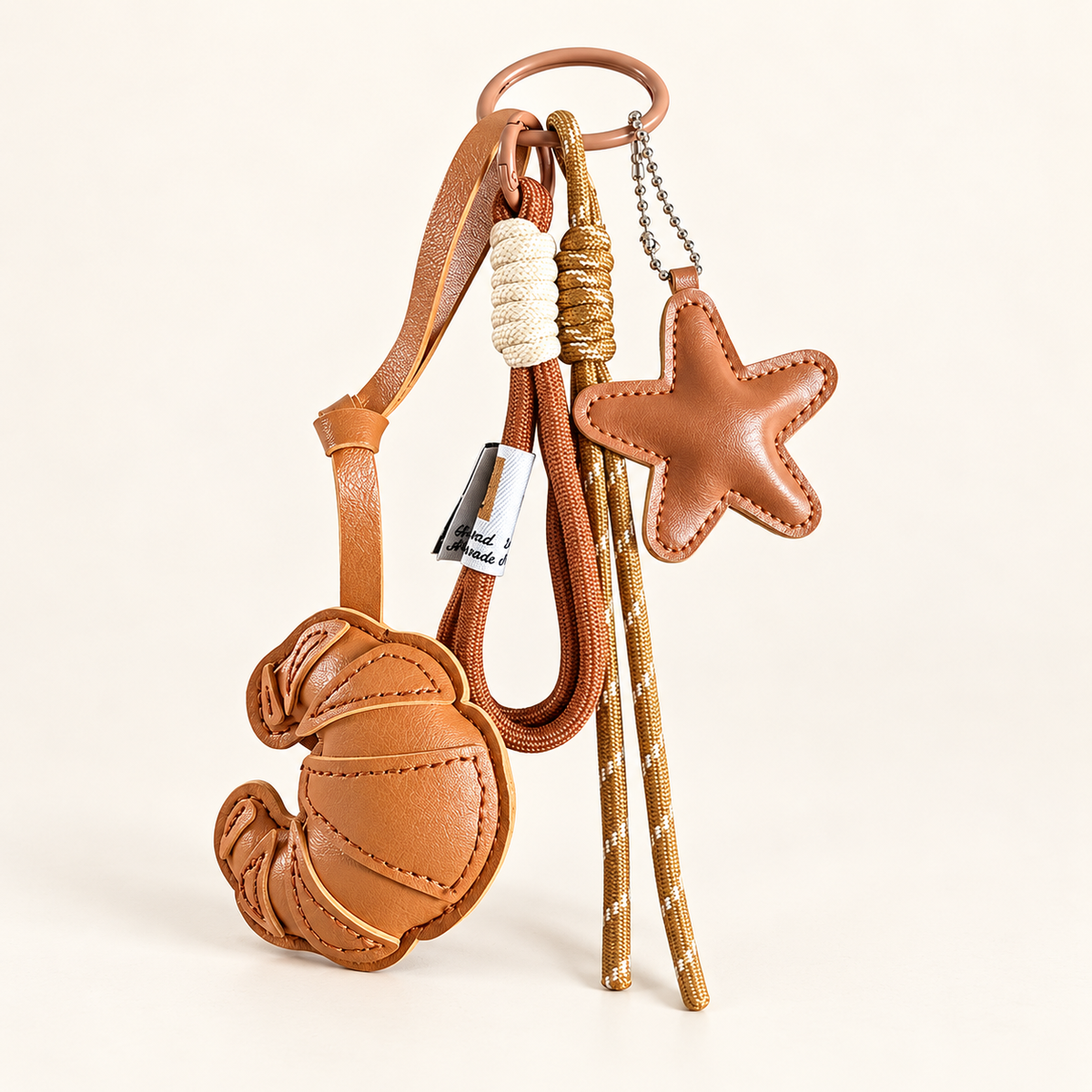 CocoaStar Croissant Leather Bag Charm — Brown — ivory studio photograph