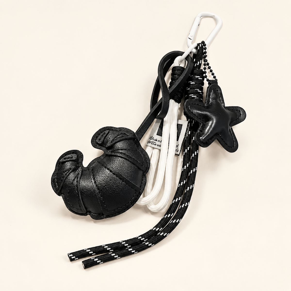 CocoaStar Croissant Leather Bag Charm — Black — ivory studio photograph