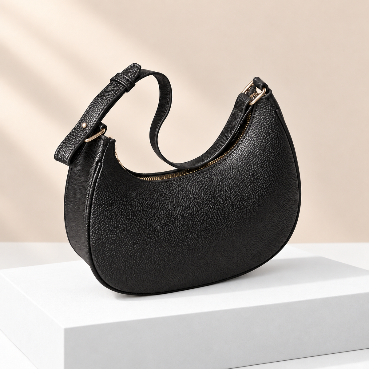 Mirevane Crescent Shoulder Bag — white plinth, warm beige background