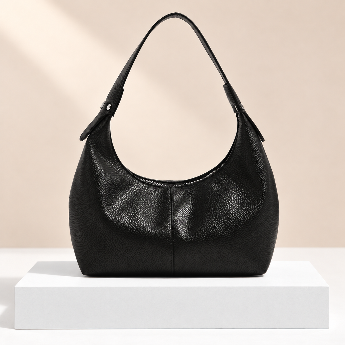 Caffelle Crescent Hobo Bag — white plinth, warm beige background