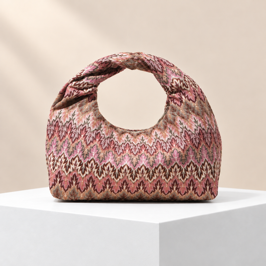 Virelia Patterned Top Handle Bag — white plinth, warm beige background