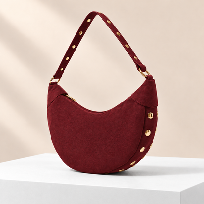 Rivora Studded Crescent Bag — white plinth, warm beige background