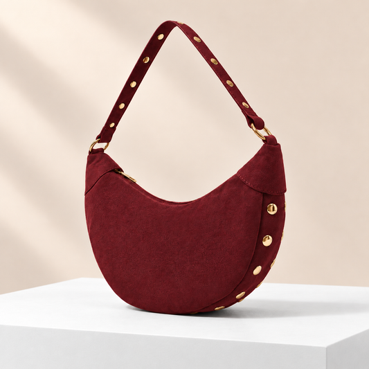 Rivora Studded Crescent Bag — white plinth, warm beige background