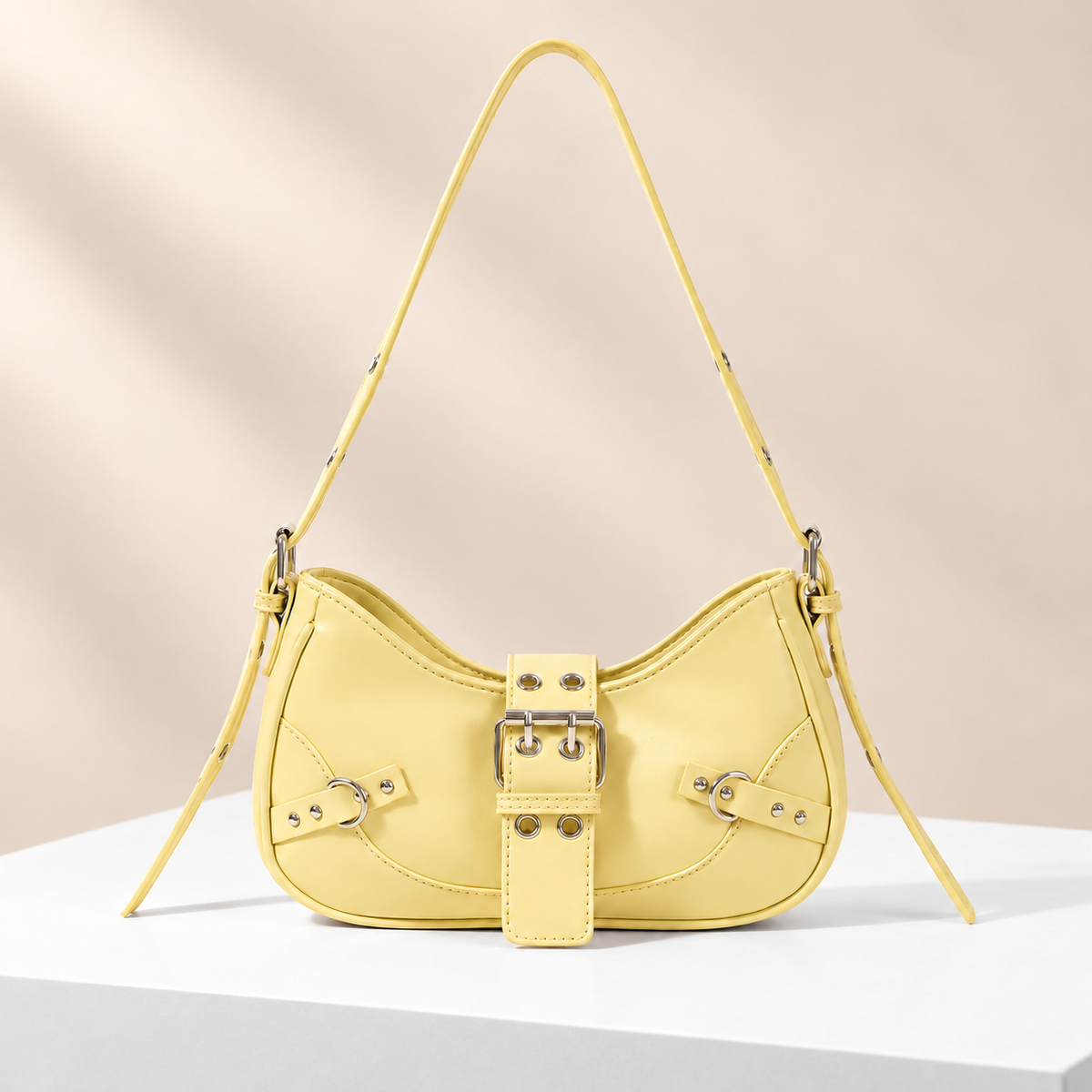 Buckelle Buckle Shoulder Bag — white plinth, warm beige background