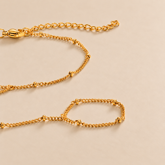 Gold Hand Chain Bracelet — warm beige studio background