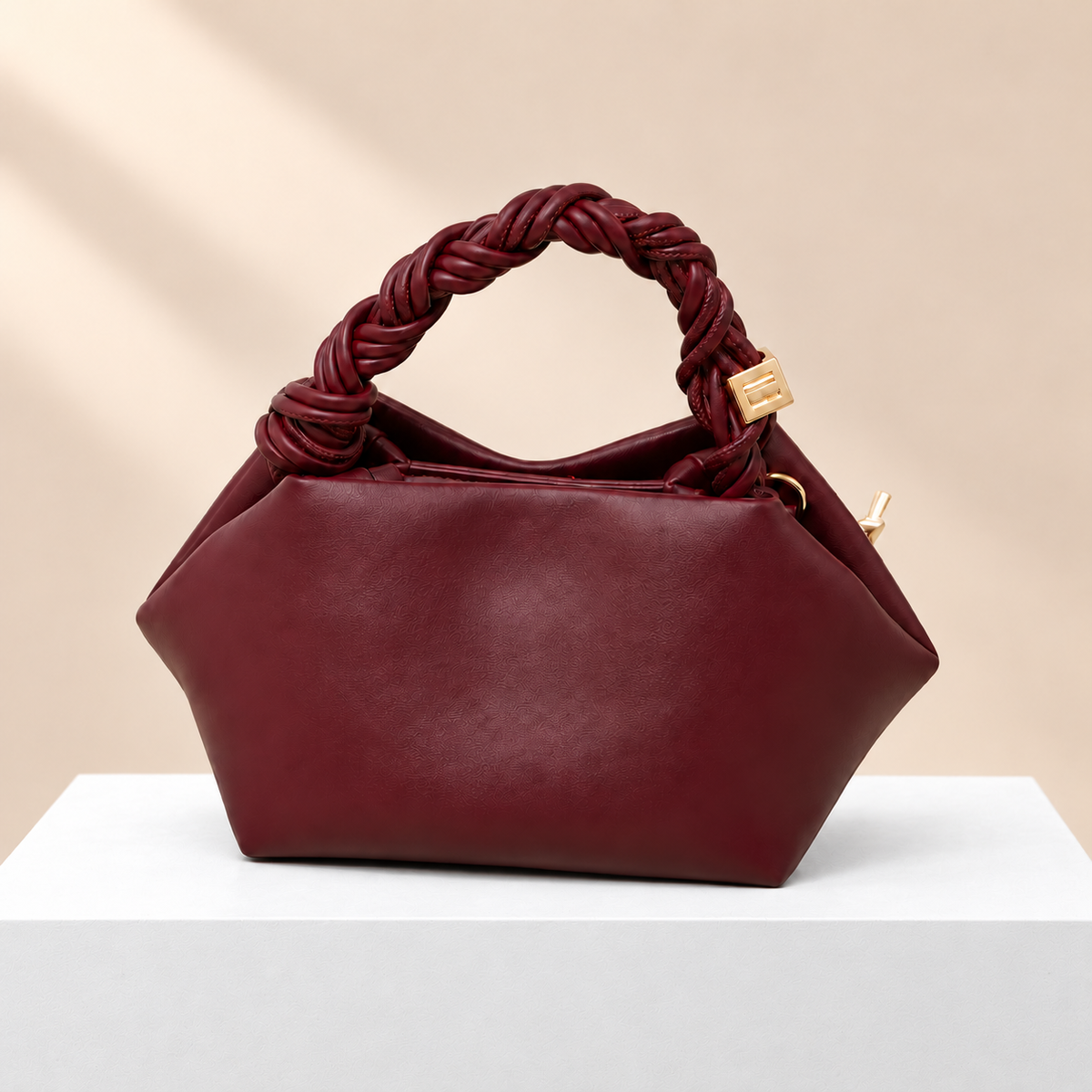 Elvoria Leather Dumpling Bag — white plinth, warm beige background