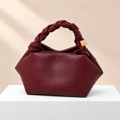 Elvoria Leather Dumpling Bag — white plinth, warm beige background